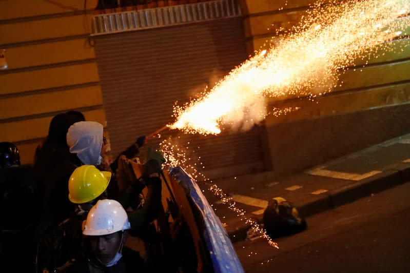 Protesters fire a flare as they clash with riot police while demonstrating against Bolivian President Evo Morales in La Paz