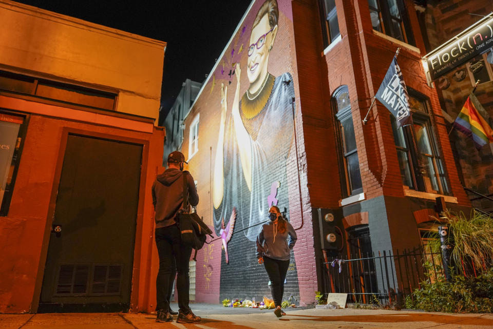 People gather under a mural of Supreme Court Justice Ruth Bader Ginsburg in the U Street neighborhood in Washington, Friday, Sept. 18, 2020, after the announcement that Ginsburg died of metastatic pancreatic cancer at age 87. (AP Photo/Pablo Martinez Monsivais)