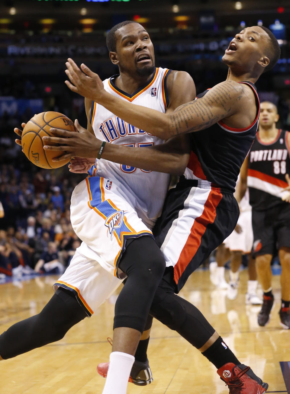 Oklahoma City Thunder forward Kevin Durant, left, fouls Portland Trail Blazers guard Damian Lillard (0) as he drives to the basket in the fourth quarter of an NBA basketball game in Oklahoma City, Tuesday, Jan. 21, 2014. Oklahoma City won 105-97. (AP Photo/Sue Ogrocki)