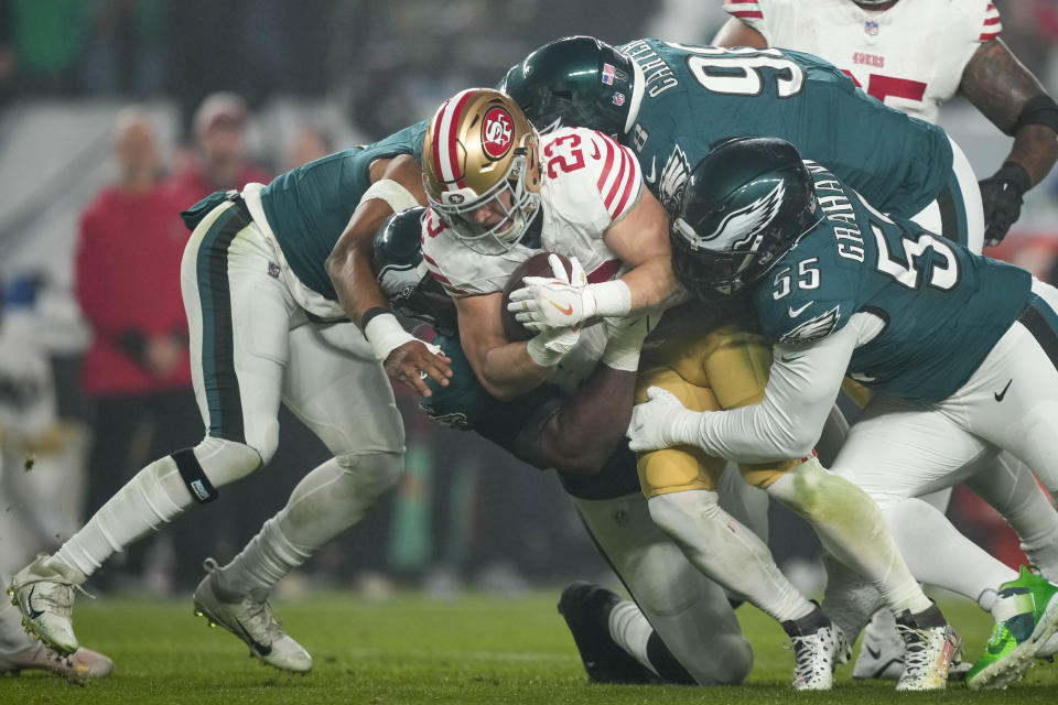 San Francisco 49ers running back Christian McCaffrey (23) is tackled by Philadelphia Eagles defensive end Brandon Graham (55) defensive tackle Jalen Carter (98) and defensive tackle Milton Williams during the second half of an NFL football game, Sunday, Dec. 3, 2023, in Philadelphia. (AP Photo/Matt Slocum)