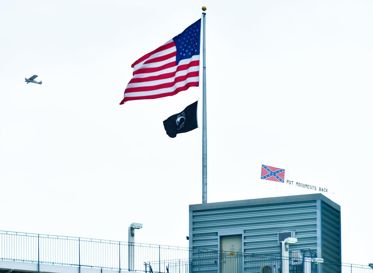 A plane pulling a banner saying "Put Monuments Back" and flying a Confederate flag circled TIAA Bank Field ahead of Sunday's NFL game between the Baltimore Ravens and the Jacksonville Jaguars.