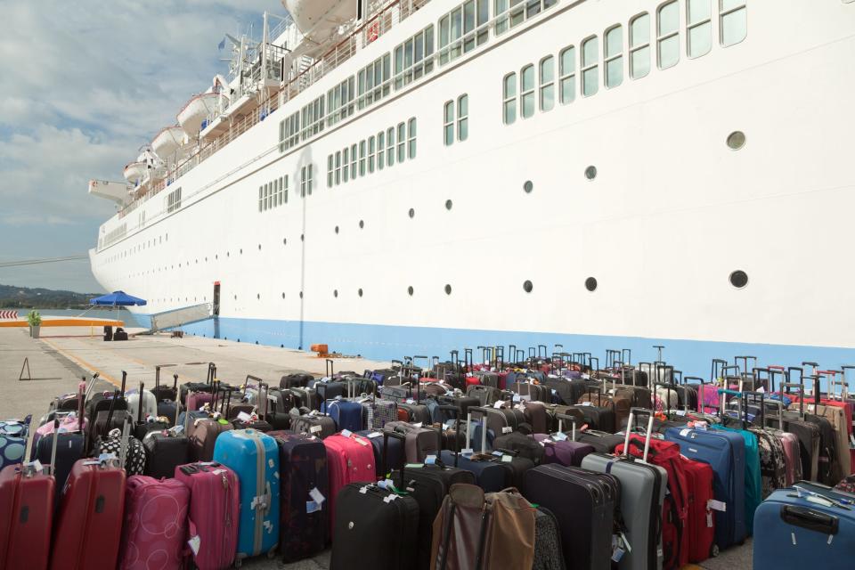 Suitcases next to cruise ship on land