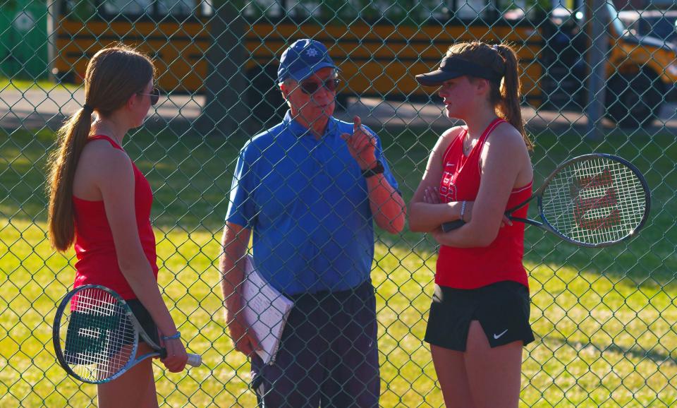 Bridgewater/Raynham tennis coach Bob Peterson huddles with his players Eily Mitchell and Annaliese Colwell during a break in their doubles match with Taunton. This was the deciding game of the match, with Mitchell and Colwell winning their set 6-2 on Tuesday, May 30, 2023.