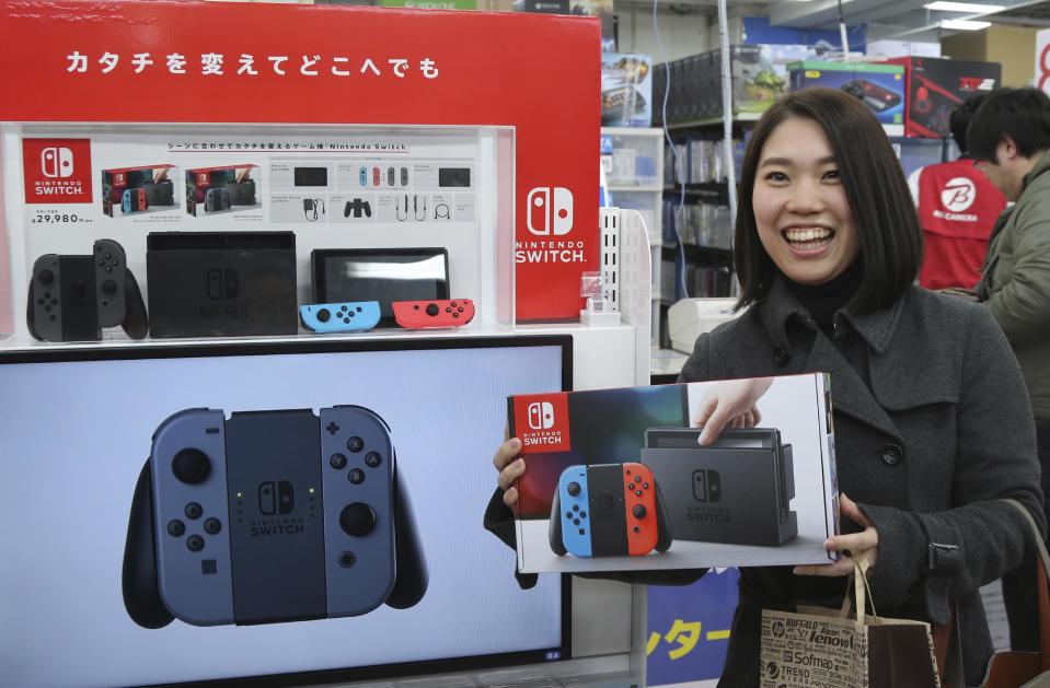 Nao Imoto, 31 years old, shows off Nintendo's newest computer game console "Switch" at a retail store Bic Camera in central Tokyo, Friday, March 3, 2017. (AP Photo/Koji Sasahara)