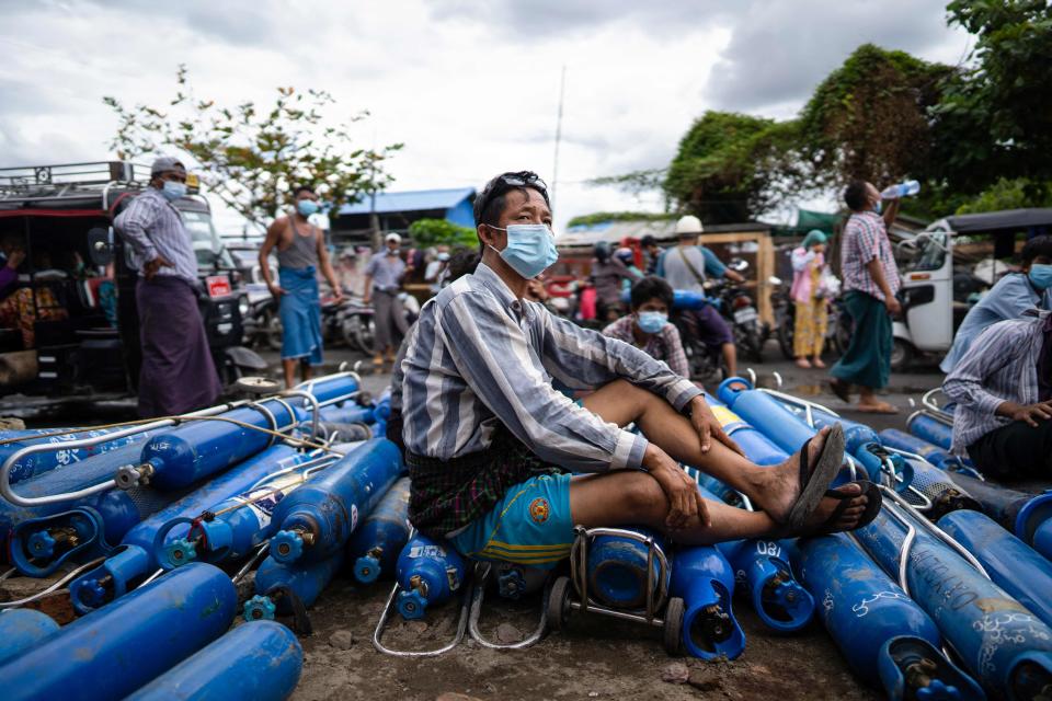 A man waits to fill oxygen canisters outside a factory July 13 in Mandalay, Myanmar, amid a surge in  coronavirus cases.