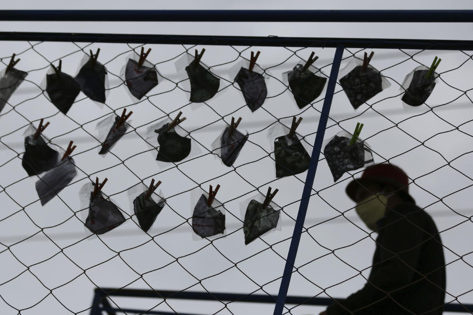 A vendor sets up masks against the spread of the new coronavirus for sale on a walkway in Valparaiso, Brazil, Wednesday, May 20, 2020. (AP Photo/Eraldo Peres)