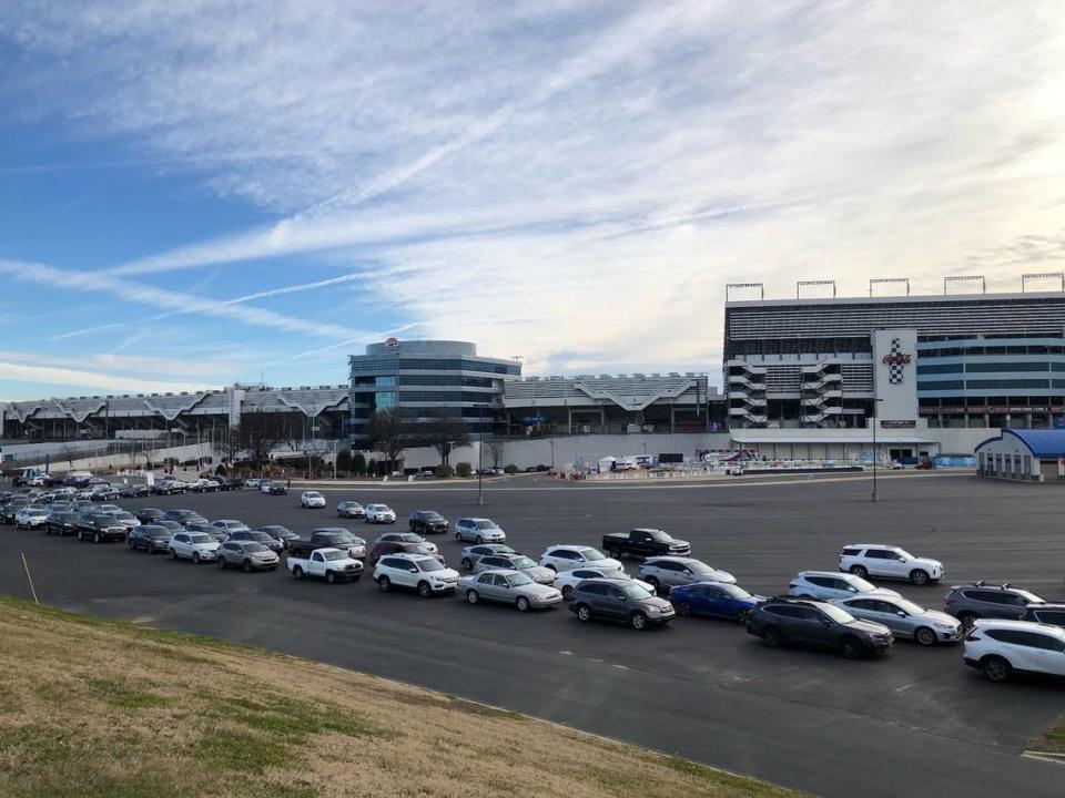 Lines of cars curve through a parking lot at Charlotte Motor Speedway as people prepare to be vaccinated for the COVID-19 virus.