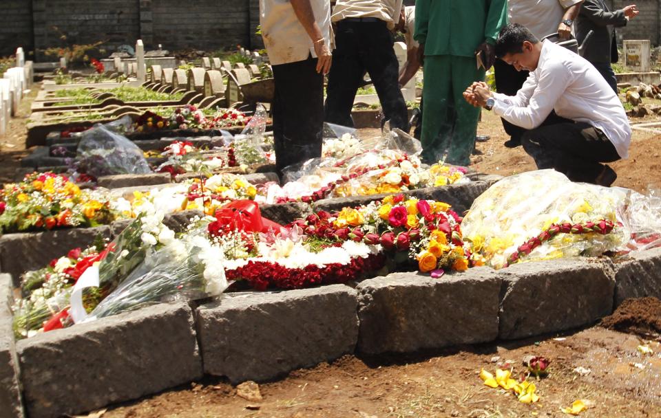 A relative prays at the grave of Kenyan journalist Ruhila Adatia Sood, who was killed in the Westgate shopping mall attack, during her funeral in Nairobi