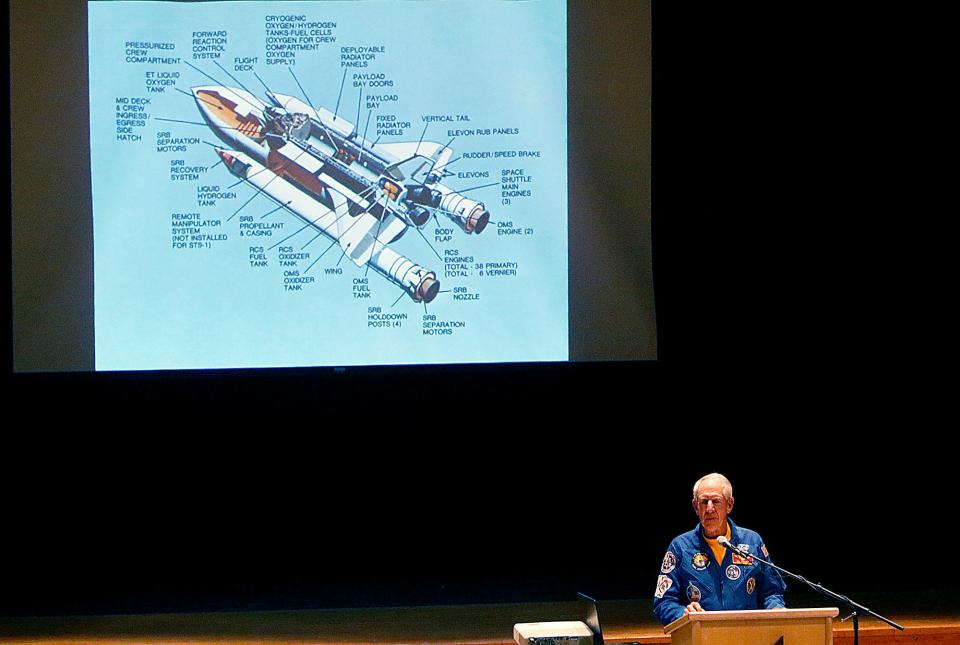 Col. Robert Springer gives his Space Talk hosted by the Ashland County Historical Society at Ashland High School's Little Theater on Thursday, March 10, 2022, while showing a photo of a space shuttle behind him on a big screen.