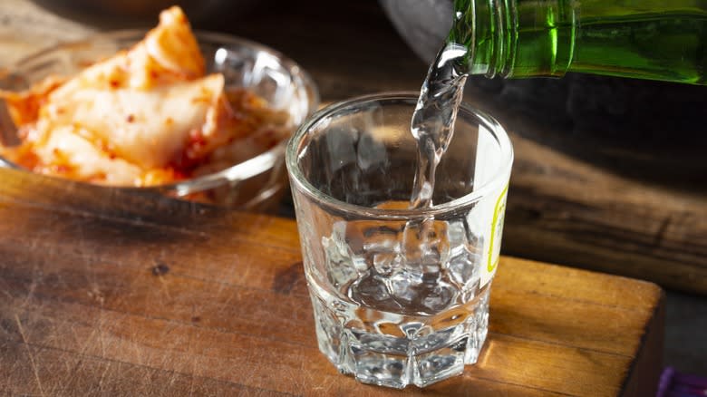 Soju being poured from a bottle into a shot glass