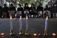 Relatives of victims of the Aug. 4 Beirut port explosion hold portraits of their loved one who killed during the explosion, during a vigil at the seaport main entrance, as they marking four months since the blast that killed more than 200 people and injured thousands, in Beirut, Lebanon Friday, Dec. 4, 2020. An investigation has yet to provide answers or hold any senior official responsible and the victims are demanding answers and justice for their loved ones. (AP Photo/Hussein Malla)