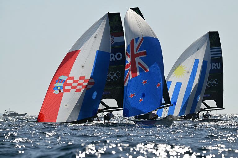 Tipico del yachting: banderas de varios países en las velas dan color a una competencia olímpica, en este caso, la de 49er masculina.