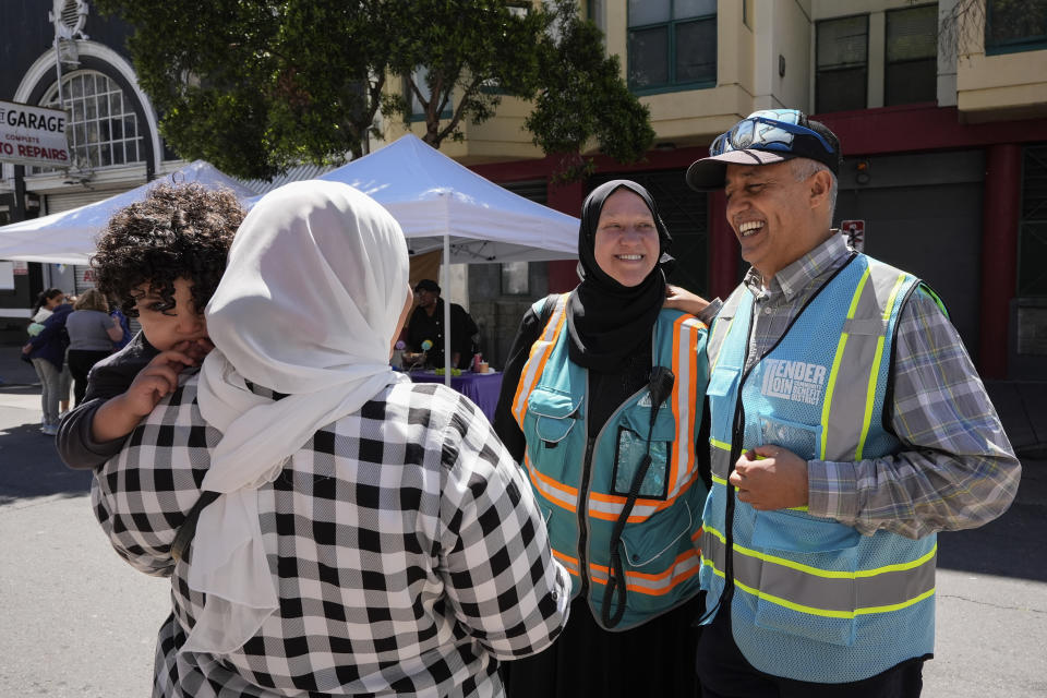 Tatiana, center, and her husband Jalal Alabsi, right, speak with their friend Shaimaa Mohamed, who is holding another friend's son Arsalan Alameri, during an Eid celebration in the Tenderloin neighborhood Saturday, April 20, 2024, in San Francisco. (AP Photo/Godofredo A. Vásquez)