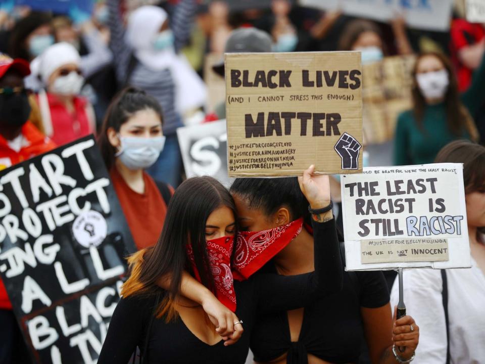 People wearing face coverings react as they hold banners in Hyde Park during a "Black Lives Matter" protest following the death of George Floyd who died in police custody in Minneapolis: REUTERS