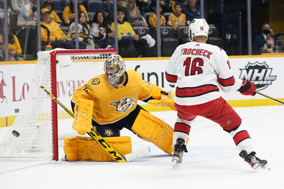 Nashville Predators goaltender Juuse Saros (74) blocks a shot as Carolina Hurricanes center Vincent Trocheck (16) watches for the rebound in the first period of an NHL hockey game Saturday, Oct. 16, 2021, in Nashville, Tenn. (AP Photo/Mark Humphrey)