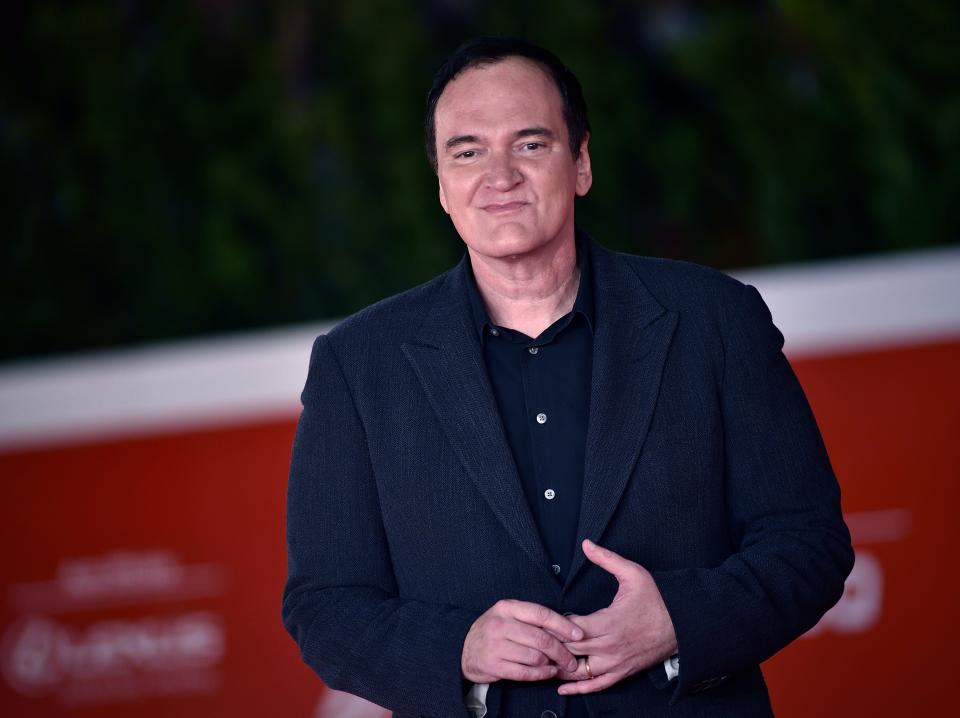 Quentin Tarantino in a navy blue suit jacket and button down shirt at the Rome Film Fest