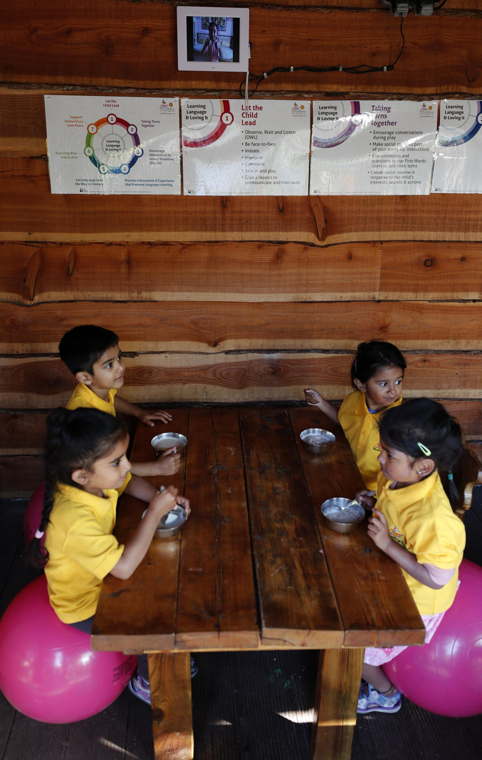 Children have breakfast at the Little Darling home-based Childcare after nurseries and primary schools partially reopen in England after the COVID-19 lockdown in London, Monday, June 1, 2020. (AP Photo/Frank Augstein)