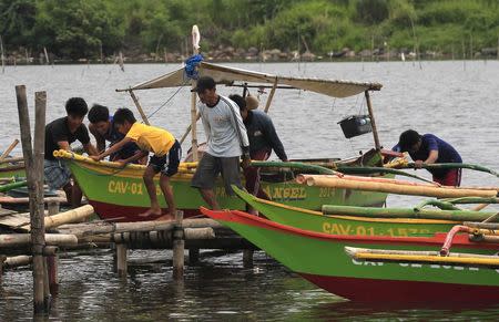 Residents secures their small boat in a safer area in preparations for the strong winds brought by Typhoon Rammasun, locally name Glenda, in a coastal area of Cavite city, south of Manila July 15, 2014. REUTERS/Romeo Ranoco