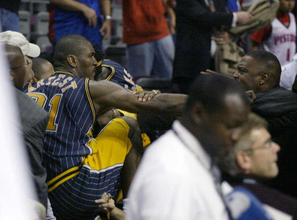 FILE - In this Nov. 19, 2004, file photo, Indiana Pacers forward Ron Artest gets into the stands to fight with some fans during a brawl st an NBA game with the Detroit Pistons, in Auburn Hills, Mich. Violence is part of the game in many sports. But when the Cleveland’s Myles Garrett ripped the helmet off Mason Rudolph and hit the Pittsburgh Steelers’ quarterback in the head with it, the Browns’ defender crossed a line _ one that attracts the attention of authorities sometimes from within their sport and in other cases from criminal prosecutors. (AP Photo/Duane Burleson, File)