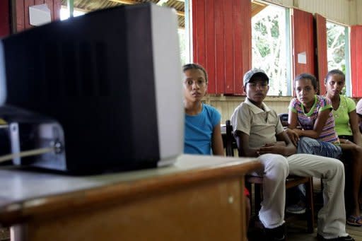 Students watch a video during a "tele-learning" class in Xapuri, in northern Brazil. Teachers, who are scarce in the Amazon, are now conducting lessons streamed to students in the village of Tumbira using an Internet connection made possible with a generator-powered radio signal