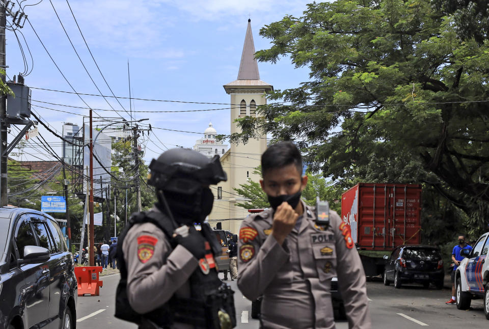 Police officers guard near a church where an explosion went off in Makassar, South Sulawesi, Indonesia, Sunday, March 28, 2021. (AP Photo/Yusuf Wahil)