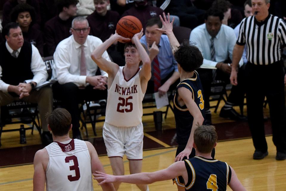 Newark senior Grant Somers shoots for 3 against defense from Lancaster senior Dominick Bornino. The Wildcats defeated the Golden Gales 51-29 in Friday night's OCC-Buckeye matchup.