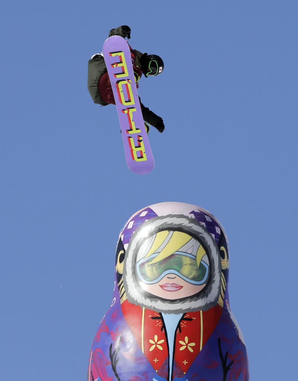 Japan's Yuki Kadono jumps near a giant matryoshka doll during a snowboard slopestyle training session at the Rosa Khutor Extreme Park, prior to the 2014 Winter Olympics, Wednesday, Feb. 5, 2014, in Krasnaya Polyana, Russia. (AP Photo/Andy Wong)