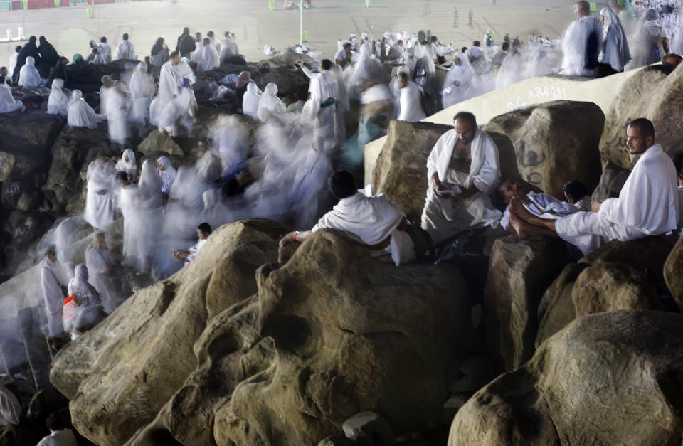 In this picture taken with low shutter speed, Muslim pilgrims make their way up on a rocky hill known as Mountain of Mercy, on the Plain of Arafat, during the annual hajj pilgrimage, ahead of sunrise near the holy city of Mecca, Saudi Arabia, Saturday, Aug. 10, 2019. More than 2 million pilgrims were gathered in the holy city of Mecca in Saudi Arabia on Friday to perform initial rites of the hajj, an Islamic pilgrimage that takes the faithful along a path traversed by the Prophet Muhammad some 1,400 years ago. (AP Photo/Amr Nabil)