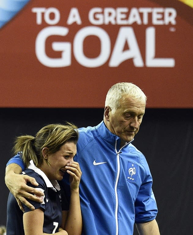 France's head coach Philippe Bergeroo comforts midfielder Claire Lavogez after their FIFA Women's World Cup quarter-final loss against Germany, at the Olympic Stadium in Montreal, Canada, on June 26, 2015