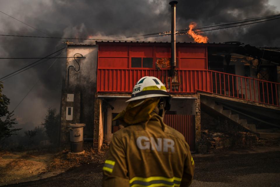 A National Guard Firefighter stands in front of a burning house at Roda village in Macao, central Portugal on July 21, 2019. (Photo: Patricia De Melo Moreira/AFP/Getty Images)