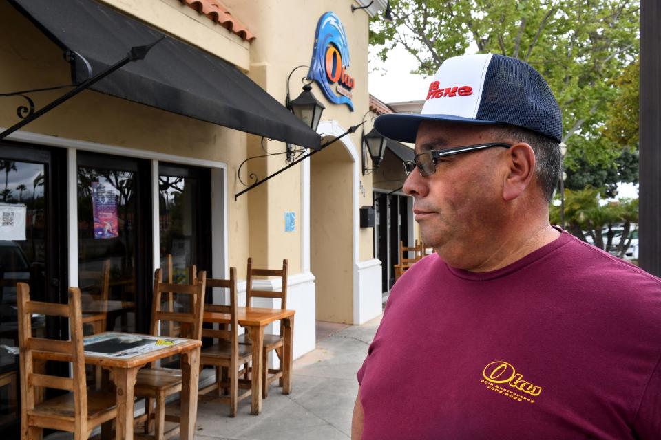 Carlos Reyes, owner of Olas de Carlos Surf Grill in Camarillo, looks out at the handicap parking spot for his business on Tuesday, May 9, 2023. The eatery is the subject of a lawsuit alleging that the slope for its disabled access parking spot is out of compliance.