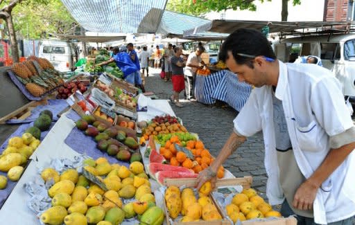 This file photo shows a vendor arranging fruits at a market in Rio de Janeiro, in 2011. Brazil's Central Bank governor on Monday expressed confidence that the country is "on track to continue the convergence toward the center of the inflation target" of around 4.5 percent, despite a spike in consumer prices, particularly food prices, in mid-July