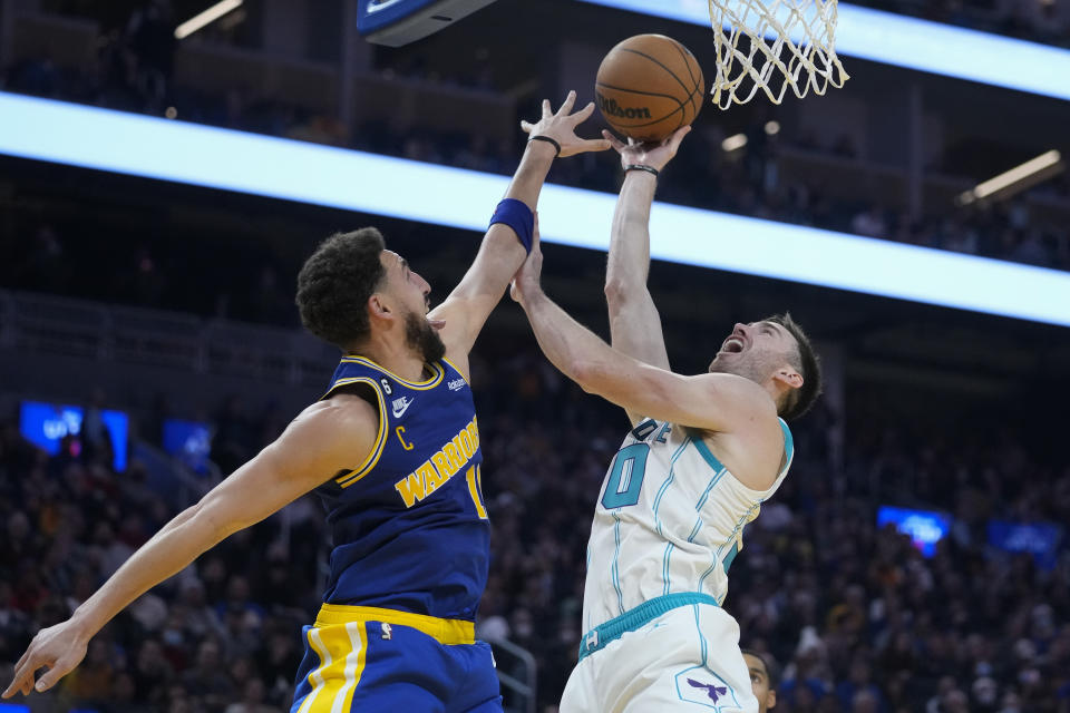 Charlotte Hornets forward Gordon Hayward, right, shoots while defended by Golden State Warriors guard Klay Thompson during the first half of an NBA basketball game in San Francisco, Tuesday, Dec. 27, 2022. (AP Photo/Godofredo A. Vásquez)