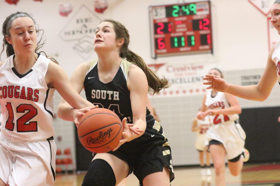 South Central's Kendyl Beverly and Crestview's Skylar Ramsey meet at the basket during the Cougars' win over South Central on Saturday.
