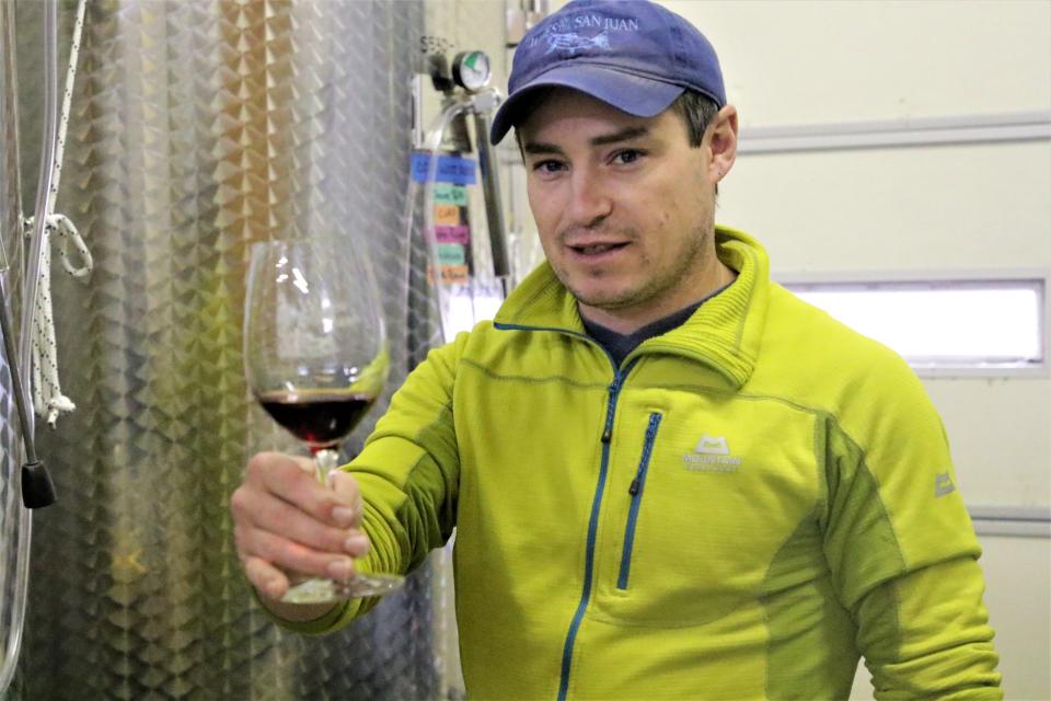 Head winemaker at Wines of the San Juan, Joshua Arnold, holds out a batch of still processing wine at Wines of the San Juan in Blanco, NM on Oct. 18, 2019.