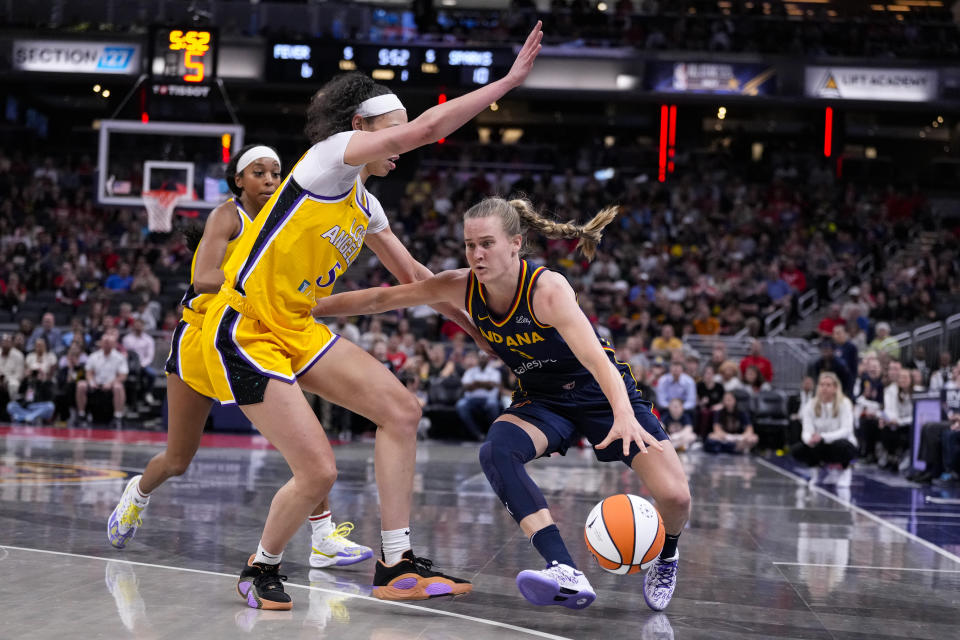 Indiana Fever guard Kristy Wallace (3) drives around Los Angeles Sparks forward Dearica Hamby (5) during the first half of a WNBA basketball game in Indianapolis, Tuesday, May 28, 2024. (AP Photo/Michael Conroy)