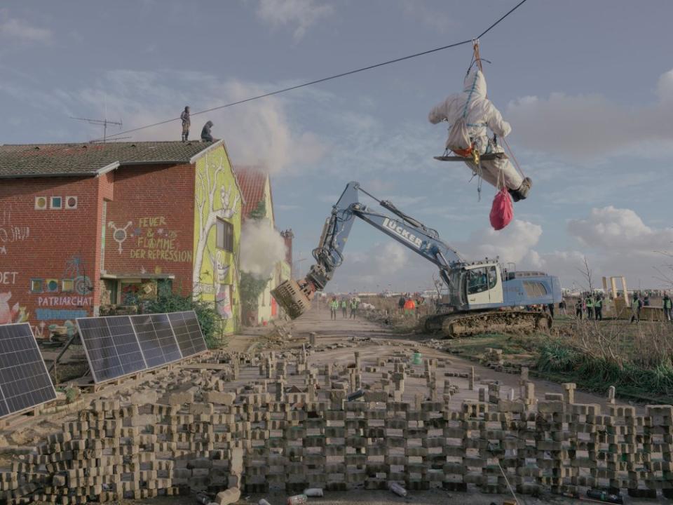 An excavator removes protesters' barricades as part of the clearing of L¸tzerath, Germany, on Jan. 11. For years, activists have tried to save tiny L¸tzerath from being razed to make way for the expansion of an open-pit coal mine.<span class="copyright">Ingmar Nolting—The New York Times/Redux</span>