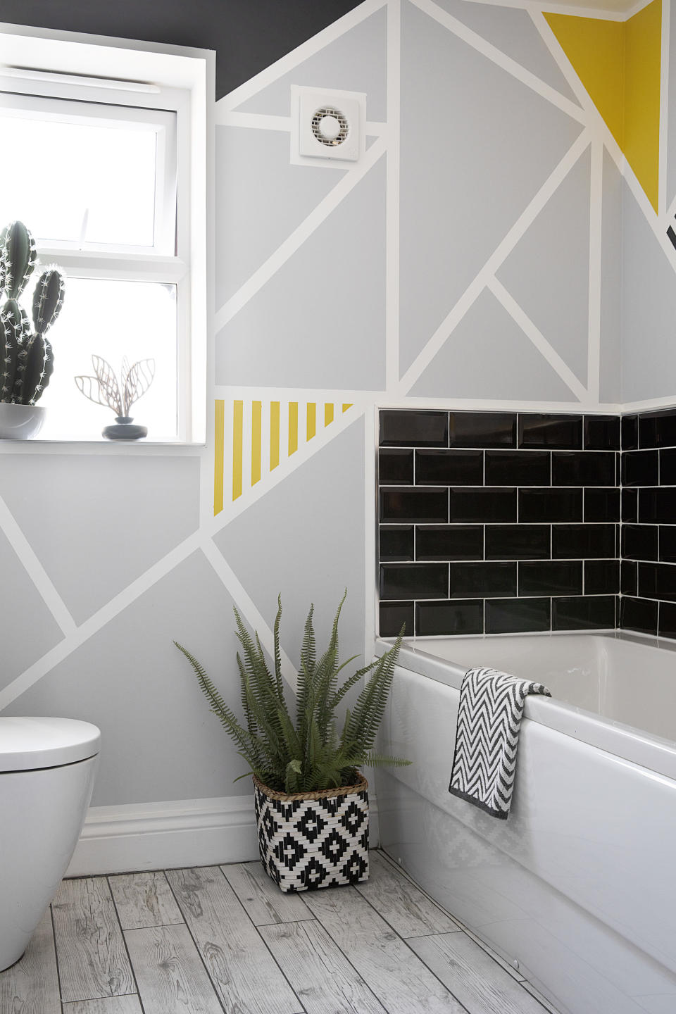 <p> You can create your own wallpaper effect with this really easy cheap bathroom idea. All you need is paint and thick masking tape. Create the geometric shapes with the masking tape and then paint in between the lines. Easy peasy. </p>