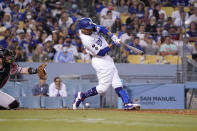 Los Angeles Dodgers' Mookie Betts, right, hits a grand slam as Arizona Diamondbacks catcher Bryan Holaday watches during the seventh inning of a baseball game Saturday, July 10, 2021, in Los Angeles. (AP Photo/Mark J. Terrill)