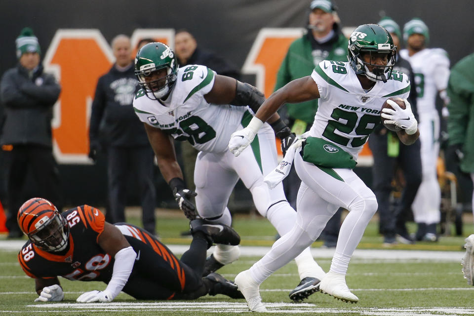 New York Jets running back Bilal Powell (29) runs the ball past Cincinnati Bengals defensive end Carl Lawson (58) during the first half of an NFL football game, Sunday, Dec. 1, 2019, in Cincinnati. (AP Photo/Frank Victores)