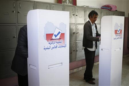 Men mark their ballots in voting booths during the municipal election at a polling station in Benghazi April 19, 2014. REUTERS/Esam Omran Al-Fetori