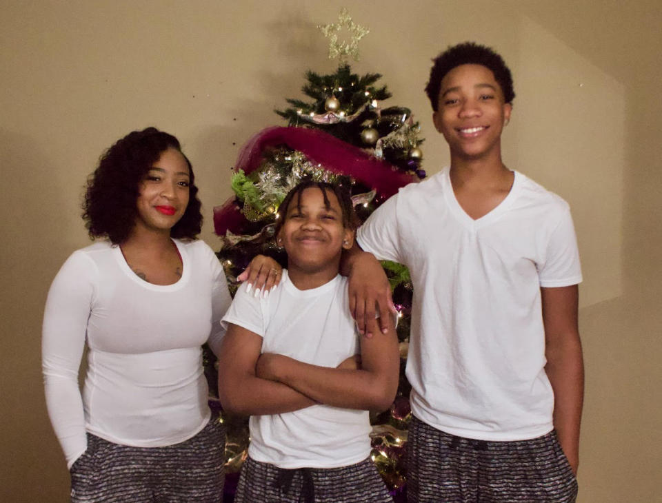 Adrian McDougles, center, with his mother Kyneshia and older brother Onterrio in December 2020. (Family photo)