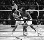 FILE - Heavyweight champion Larry Holmes seems to pepper Muhammad Ali at will in a battle at Caesars' Palace in Las Vegas on Oct. 3, 1980. Despite Ali's covering up as he does here, Holmes was pretty much able to pepper Ali at will. Holmes successfully defended his crown when Ali failed to answer the bell at the start of the 11th round. (AP Photo/File)