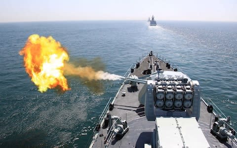 In this photo released by China's Xinhua News Agency, Chinese navy's missile destroyer DDG-112 Harbin fires a shell during the China-Russia joint naval exercise in the Yellow Sea - Credit: Xinhua
