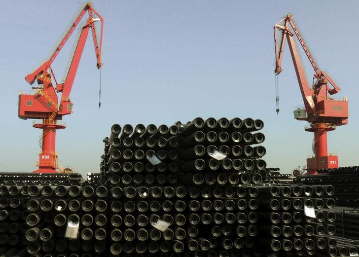 FILE PHOTO: Cranes are seen above piles of steel pipes to be exported at a port in Lianyungang