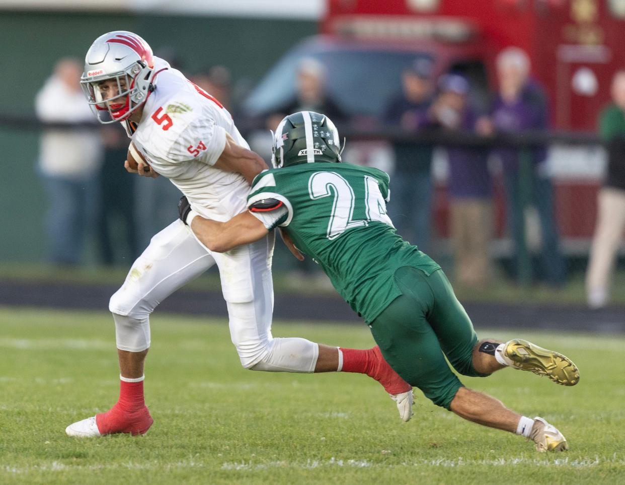 Sandy Valley quarterback Nick Petro fights off the tackle of Malvern's Ryan Runyon in the first half, Friday, Sept. 15, 2023.