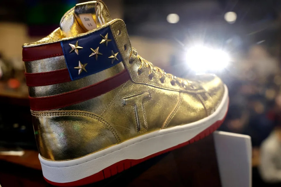 The bright gold high top shoes are emblazoned with a large ‘T’ on the side and the US flag stitched around the collar (Getty Images)