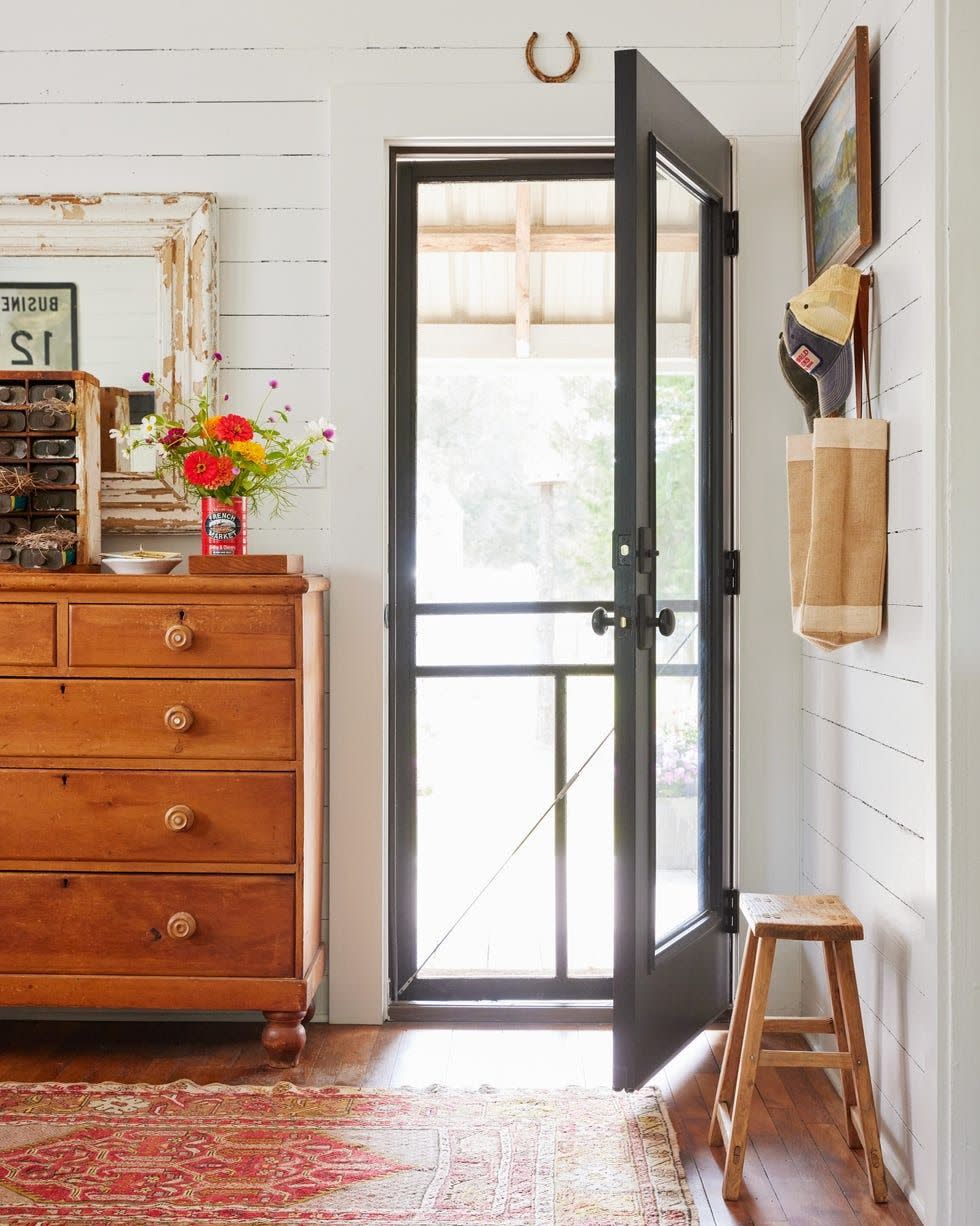 farmhouse entry with white shiplap walls and black door