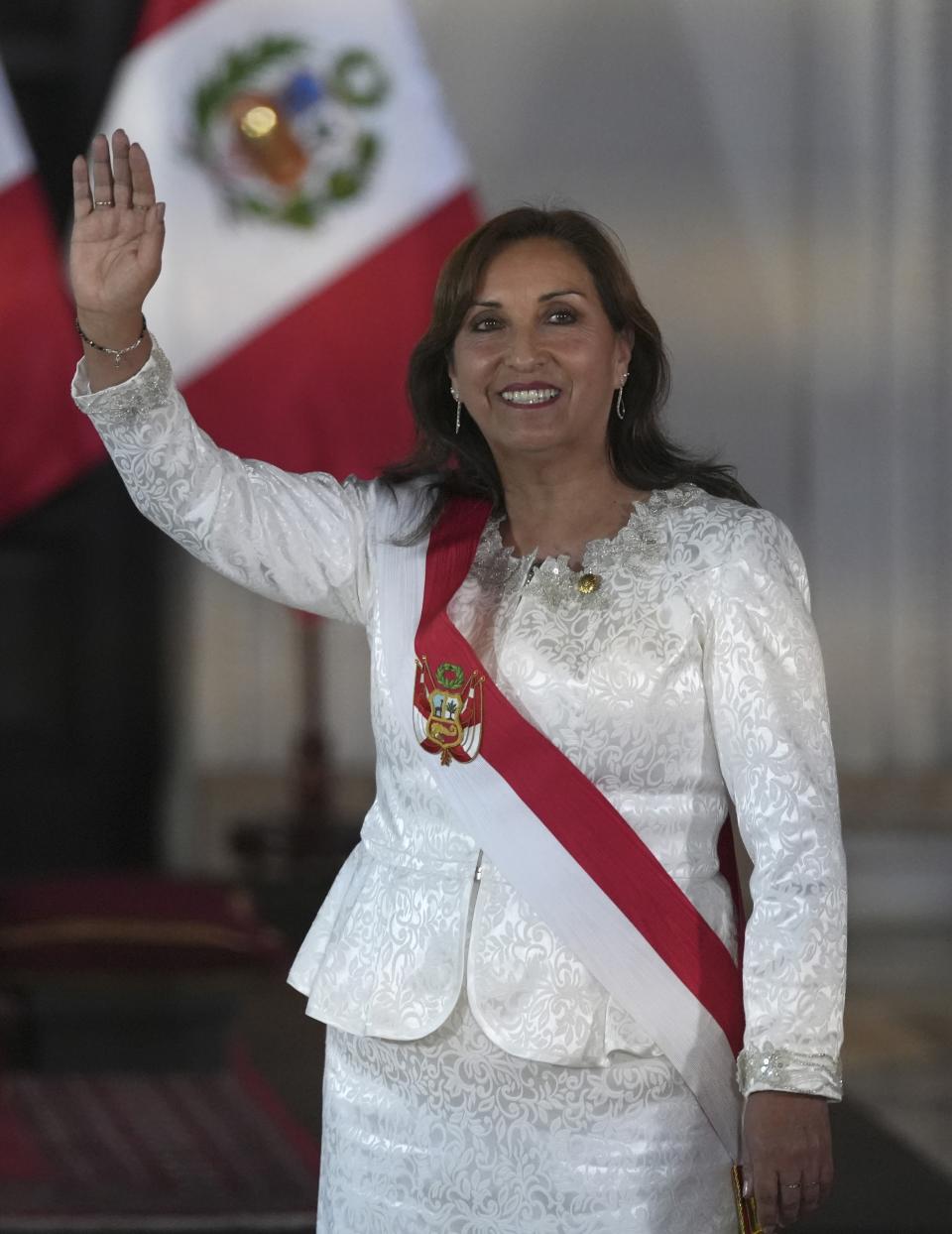 Peru's President Dina Boluarte waves as she arrives to swear in her cabinet members at the government palace in Lima, Peru, Saturday, Dec. 10, 2022. (AP Photo/Guadalupe Pardo)