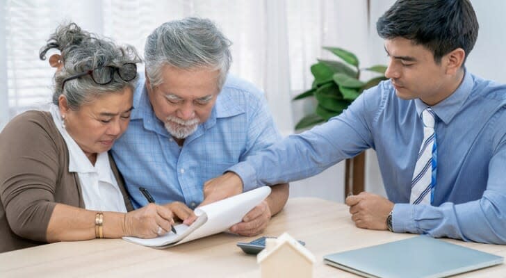 Een gepensioneerd echtpaar neemt hun hypotheekdocumenten door met hun leningfunctionaris. Een hypotheek krijgen met alleen socialezekerheidsuitkeringen is mogelijk, maar geen inkomen uit een baan of pensioenrekeningen kan het moeilijker maken om in aanmerking te komen voor een woningkrediet.